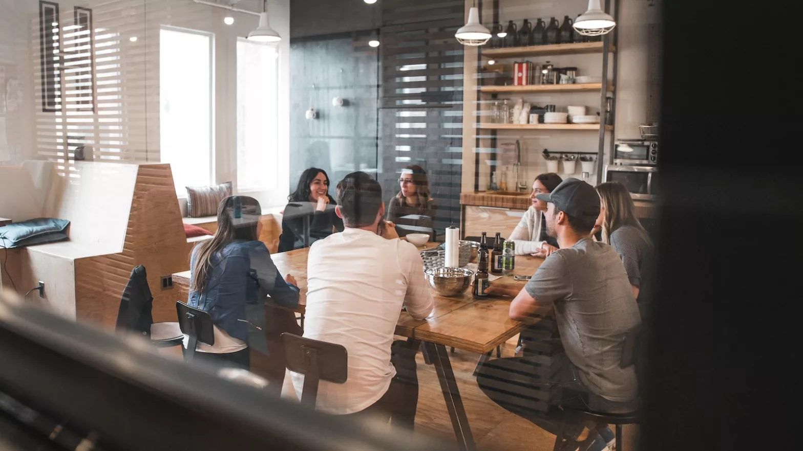 A group of diverse people sitting around a table, engaged in a discussion. This image represents the collaborative nature of the workplace and sets the stage for the discussion on the Baarda Model.