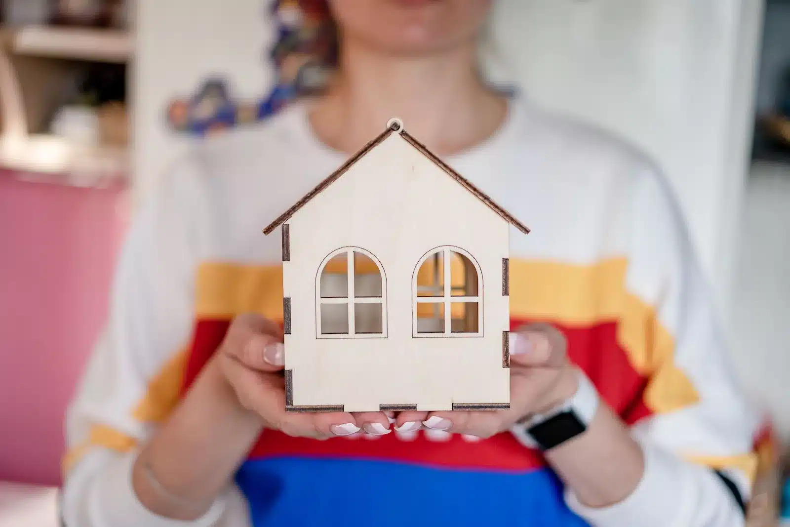 A pair of hands holding a model or miniature of a building, symbolizing the concept of the Baarda Model.